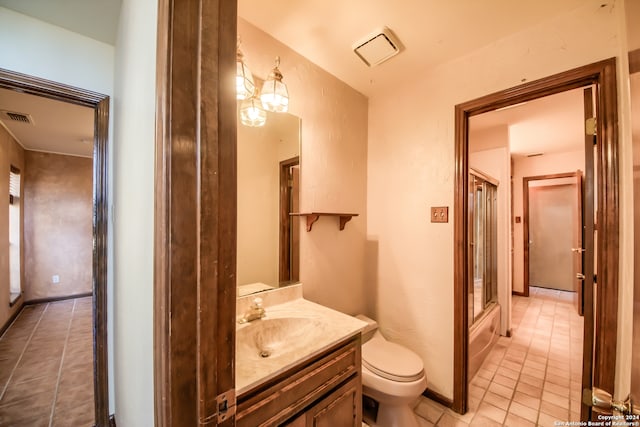 full bathroom with toilet, vanity, tile patterned floors, and bath / shower combo with glass door