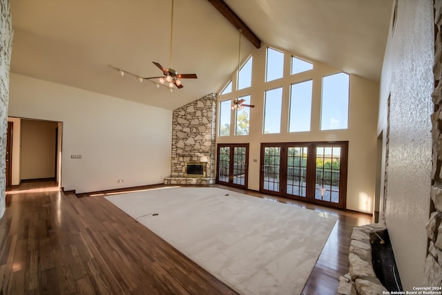 unfurnished living room featuring dark hardwood / wood-style floors, ceiling fan, a fireplace, and high vaulted ceiling