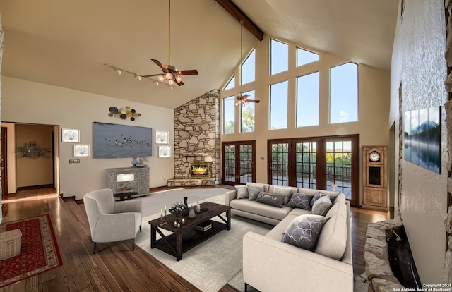 living room featuring beam ceiling, ceiling fan, high vaulted ceiling, a fireplace, and hardwood / wood-style flooring