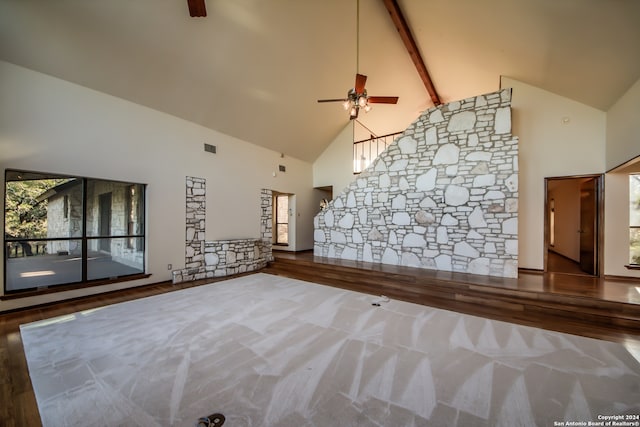 unfurnished living room featuring beamed ceiling, ceiling fan, wood-type flooring, and high vaulted ceiling