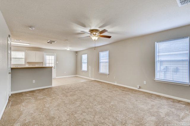 empty room featuring ceiling fan and light carpet