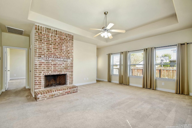 unfurnished living room featuring a raised ceiling and light colored carpet