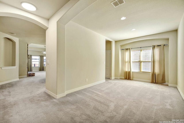 carpeted empty room featuring ceiling fan and a healthy amount of sunlight