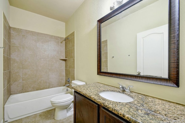 full bathroom with tile patterned floors, vanity, tiled shower / bath, and toilet