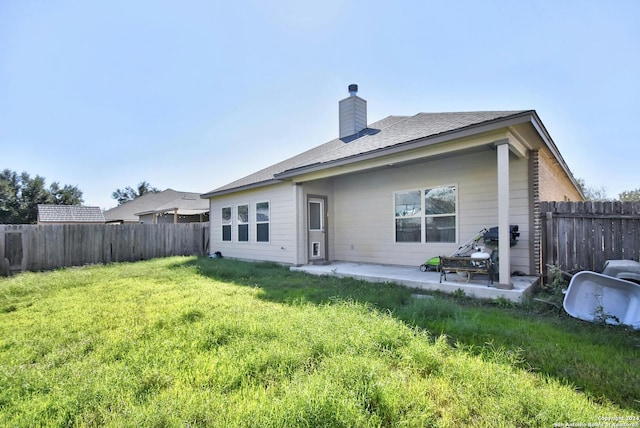 rear view of house with a yard and a patio