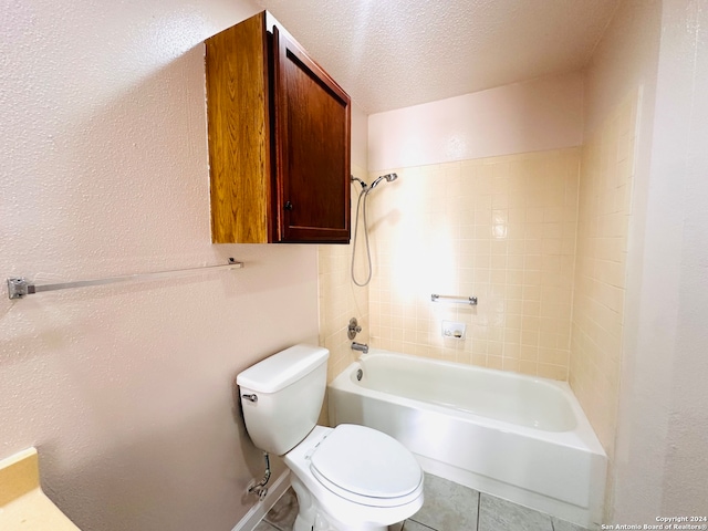 bathroom featuring tile patterned flooring, toilet, a textured ceiling, and tiled shower / bath