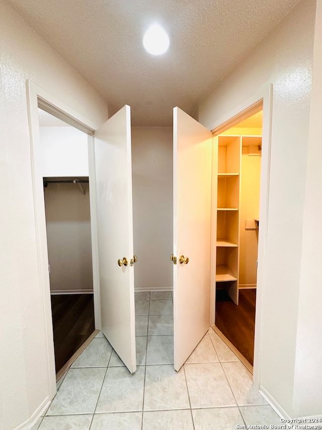 bathroom with a textured ceiling and tile patterned floors