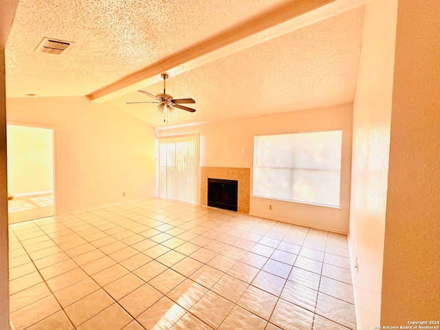 unfurnished living room featuring lofted ceiling with beams, light tile patterned flooring, a textured ceiling, and ceiling fan