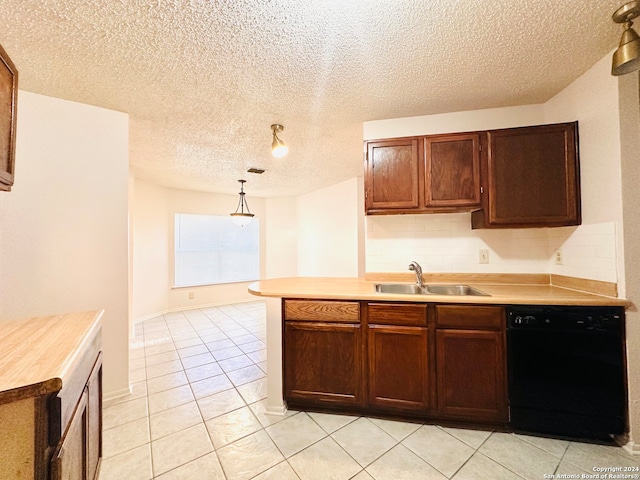 kitchen featuring pendant lighting, sink, light tile patterned floors, black dishwasher, and a textured ceiling