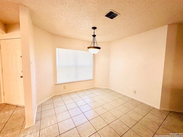 unfurnished room featuring light tile patterned floors and a textured ceiling