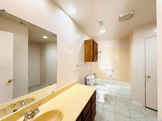 full bathroom with vanity, tile patterned floors, tiled shower / bath combo, toilet, and a textured ceiling