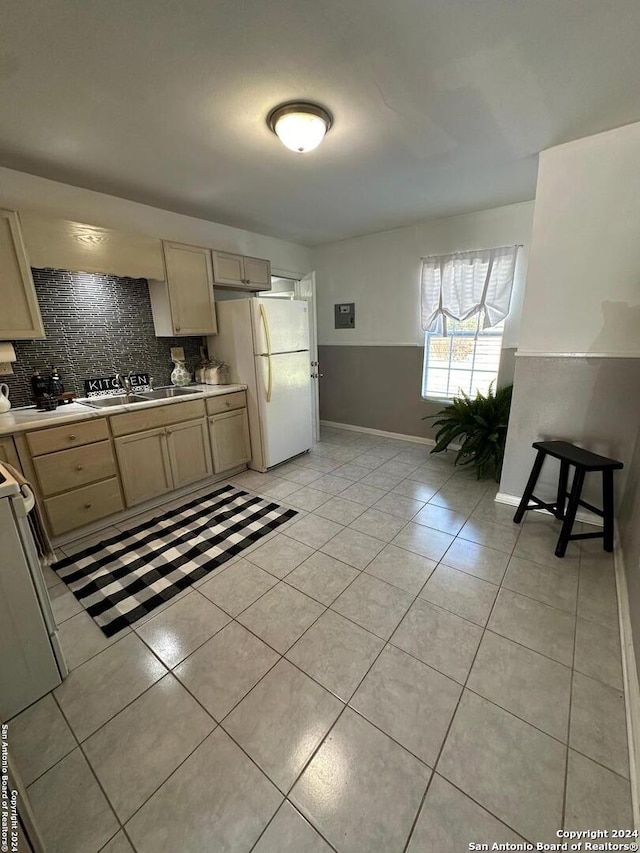 kitchen featuring light brown cabinets, white appliances, light tile patterned floors, and backsplash