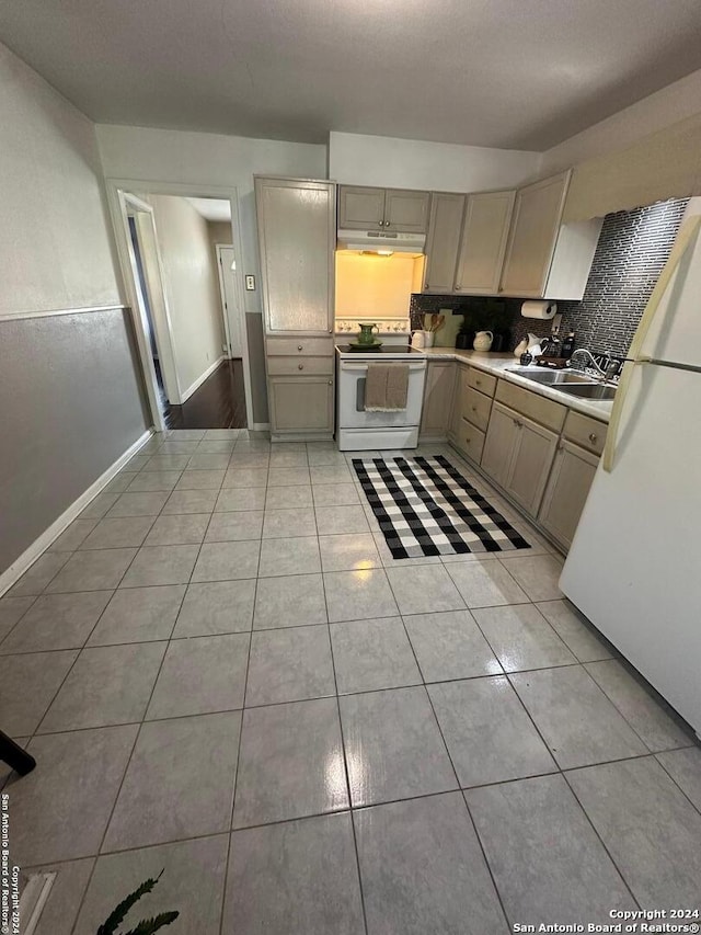 kitchen featuring light tile patterned floors, white appliances, tasteful backsplash, and sink