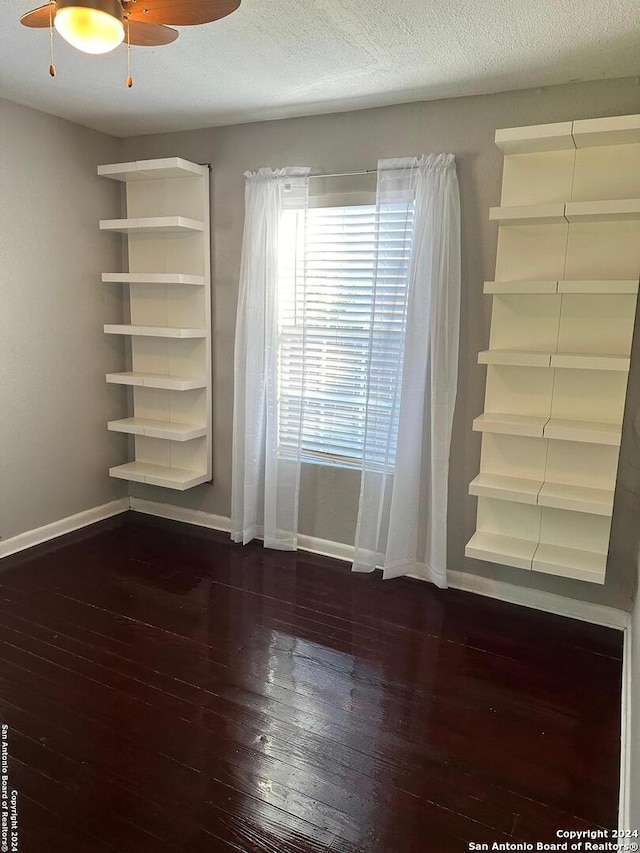 spare room with ceiling fan, dark hardwood / wood-style flooring, and a textured ceiling