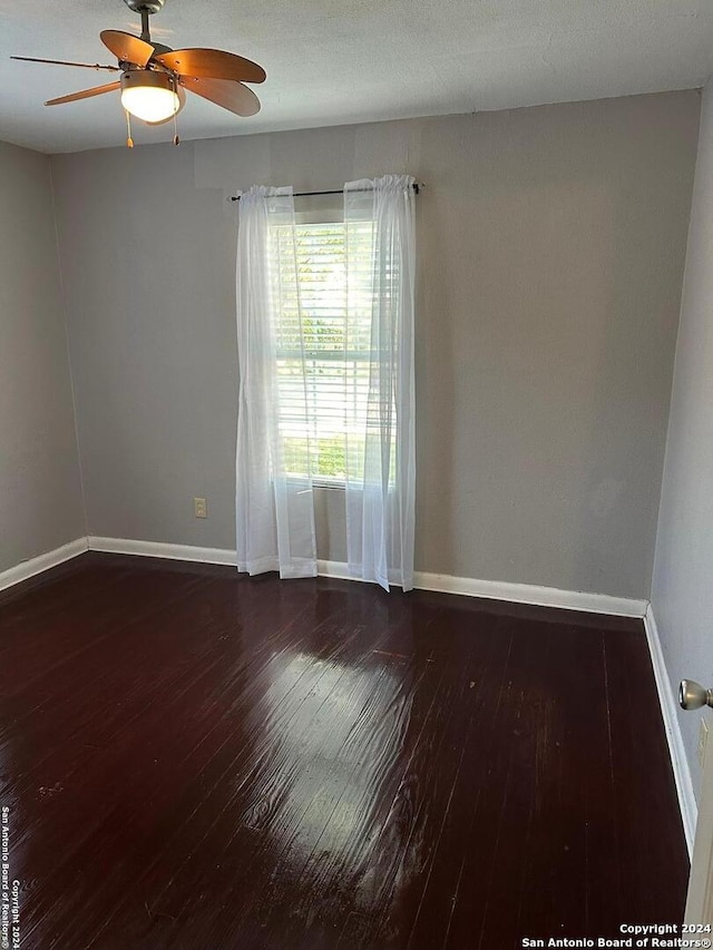 unfurnished room featuring ceiling fan and dark hardwood / wood-style flooring