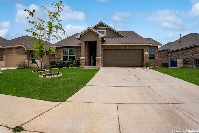 craftsman-style home featuring a garage, central air condition unit, and a front lawn