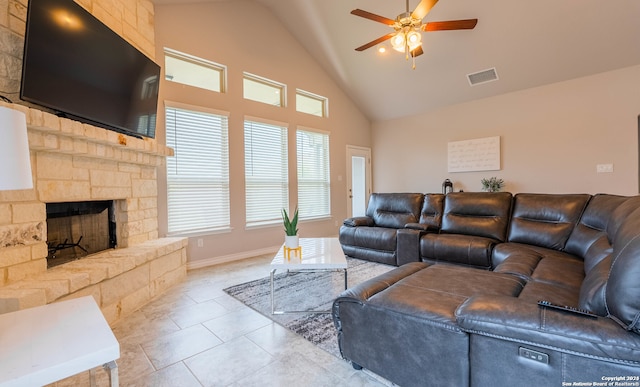 tiled living room with high vaulted ceiling, ceiling fan, and a stone fireplace