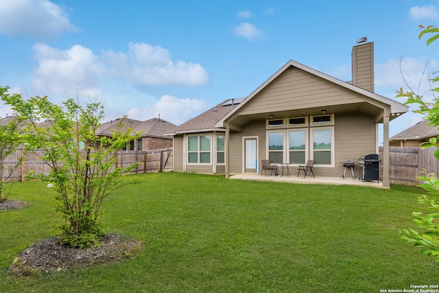 rear view of house featuring a patio area and a yard