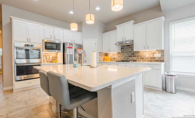 kitchen with white cabinetry, sink, hanging light fixtures, tasteful backsplash, and appliances with stainless steel finishes