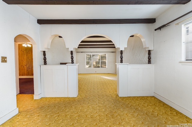 empty room featuring beam ceiling