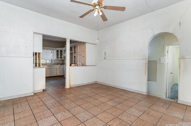 unfurnished room featuring ceiling fan and wooden walls