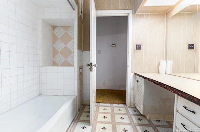 bathroom with vanity, tile walls, and a bathing tub