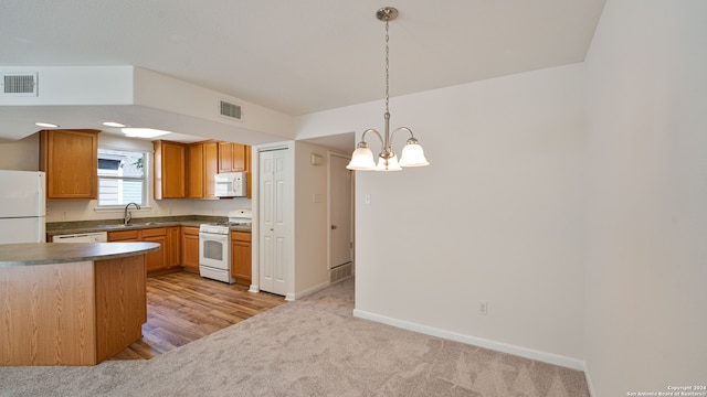 kitchen featuring sink, light hardwood / wood-style flooring, a notable chandelier, decorative light fixtures, and white appliances