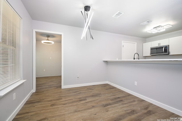 kitchen featuring white cabinets, pendant lighting, dark hardwood / wood-style floors, and sink