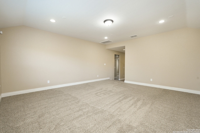 empty room featuring carpet and lofted ceiling