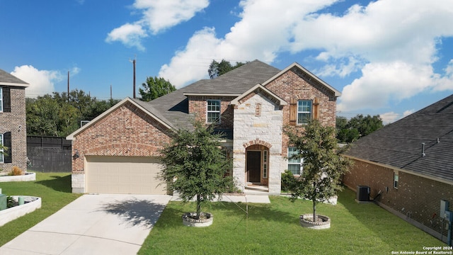 view of front of home featuring a front lawn, cooling unit, and a garage