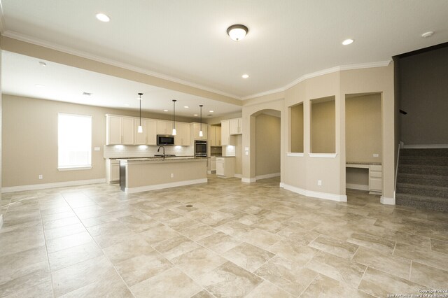 unfurnished living room featuring ornamental molding and sink