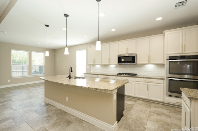 kitchen with a kitchen island with sink, sink, decorative light fixtures, white cabinetry, and stainless steel appliances