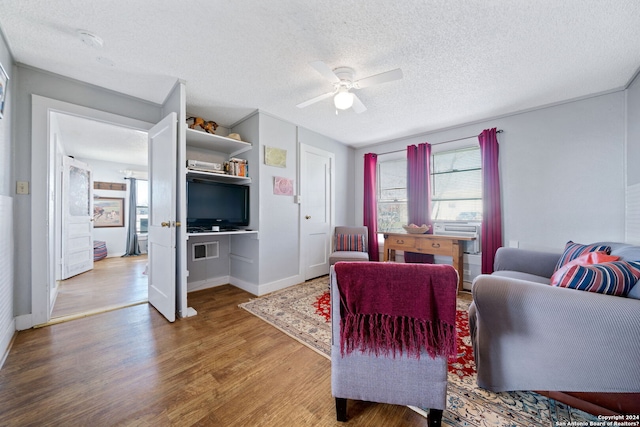 living room featuring ceiling fan, hardwood / wood-style floors, and a textured ceiling