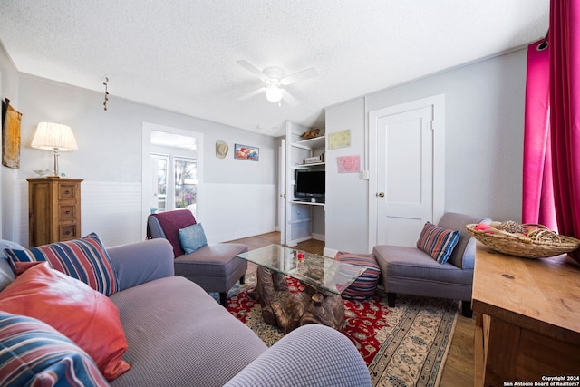 living room with a textured ceiling, dark hardwood / wood-style floors, and ceiling fan