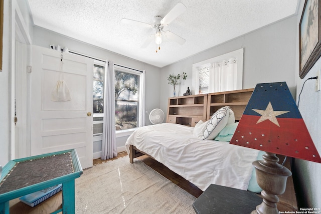 bedroom with ceiling fan and a textured ceiling