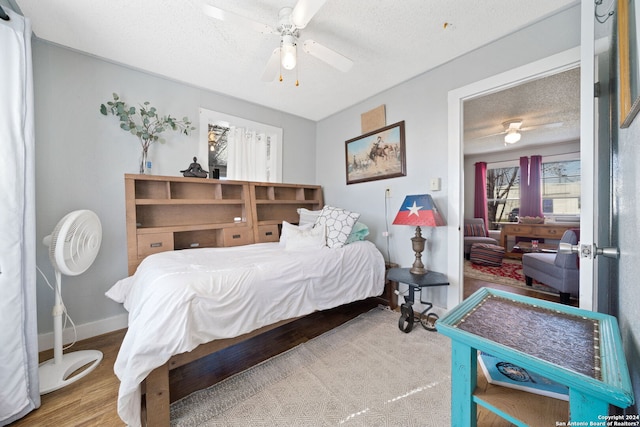 bedroom with wood-type flooring, a textured ceiling, and ceiling fan