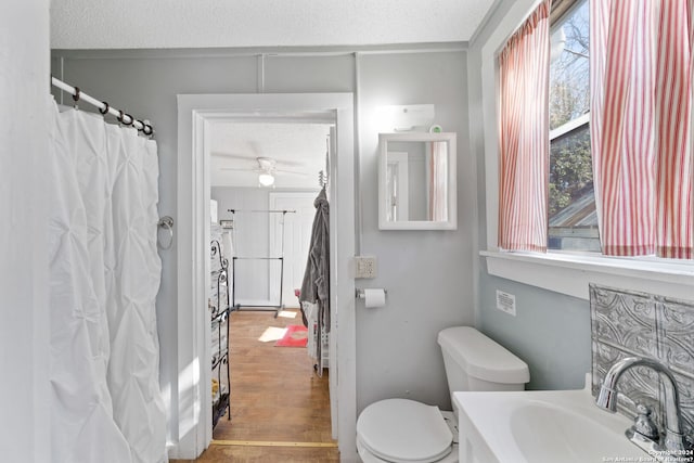 bathroom with vanity, ceiling fan, toilet, a textured ceiling, and wood-type flooring