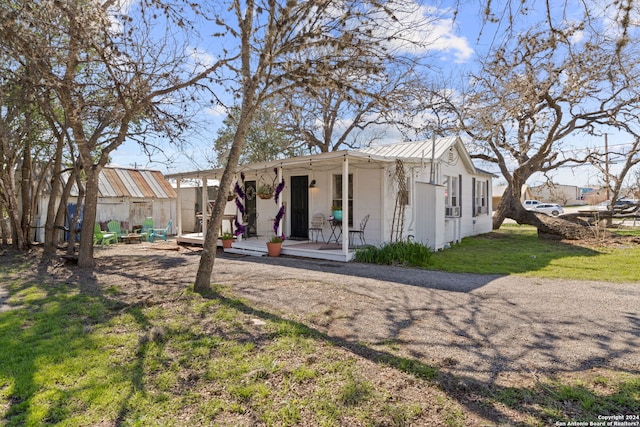 rear view of house with a porch and a lawn