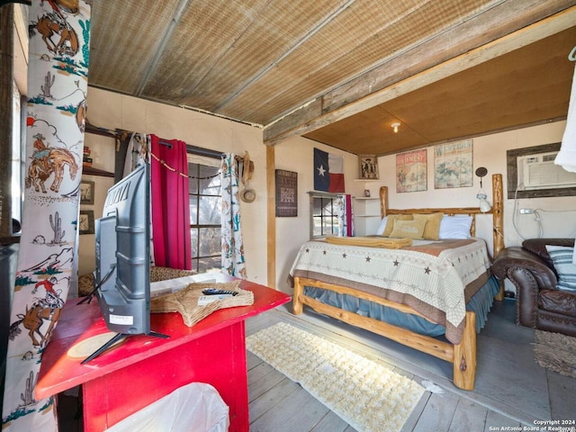 bedroom with an AC wall unit and hardwood / wood-style floors