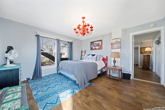 bedroom featuring a notable chandelier and dark hardwood / wood-style flooring