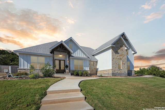 craftsman-style house featuring a yard and french doors