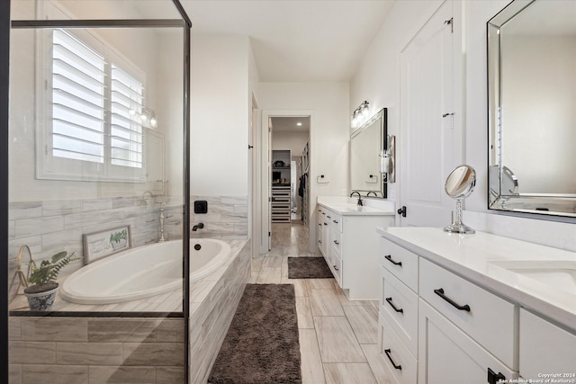 bathroom with tiled bath and vanity