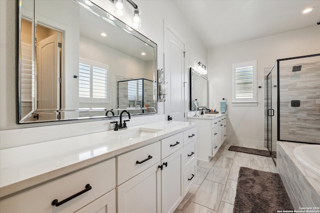 bathroom featuring vanity and independent shower and bath