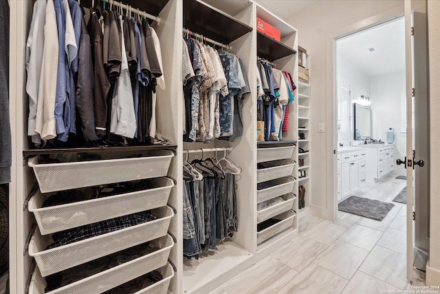 walk in closet with tile patterned flooring and sink