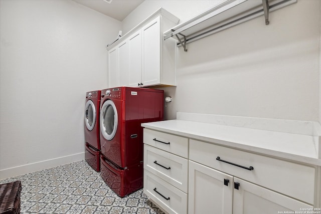 clothes washing area featuring separate washer and dryer and cabinets