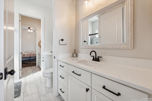 bathroom featuring ceiling fan, vanity, hardwood / wood-style flooring, and toilet