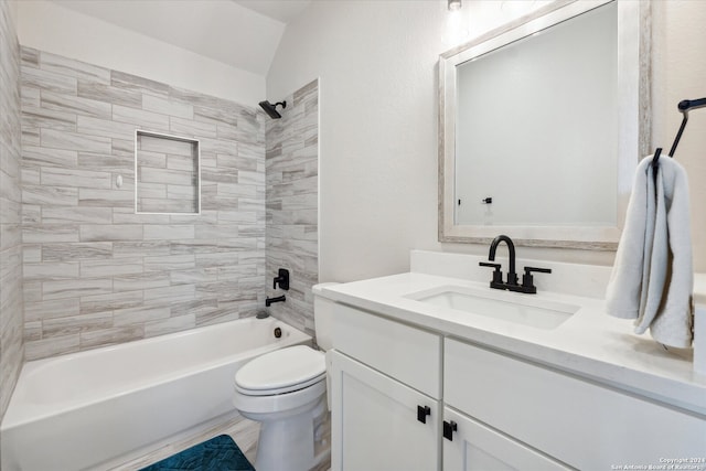 full bathroom with tiled shower / bath combo, toilet, vanity, and vaulted ceiling