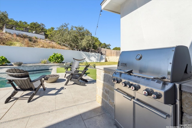 view of patio featuring a fenced in pool and area for grilling