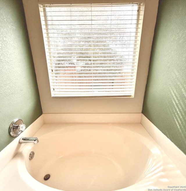 6050 Lakefront, San Antonio, TX 78222 - bathroom featuring a bath, plenty of natural light, and a textured wall