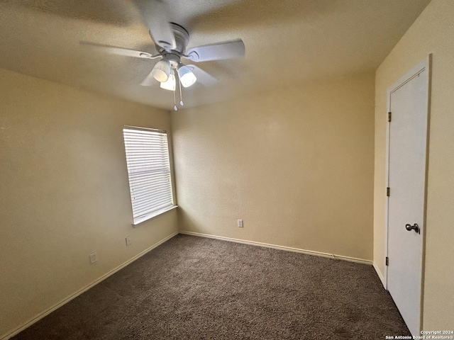 6050 Lakefront, San Antonio, TX 78222 - unfurnished room with dark colored carpet, ceiling fan, and baseboards